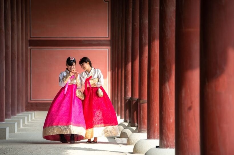 Korean Film Festival 2 Koreans wearing hanboks while scrolling through their phone for the Korean Film Festival in Abu Dhabi this 2024