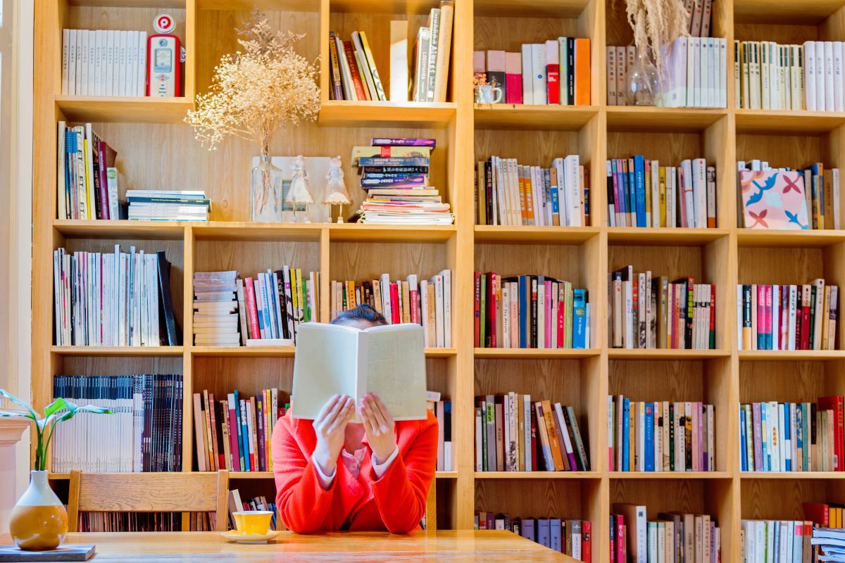 International Literacy Day A lady in the library holding and reading a book for International Literacy Day