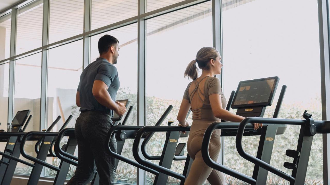 etizan fitness one of the best gyms in abu dhabi this 2025 featuring etizan fitness, couple of gym people running on threadmill